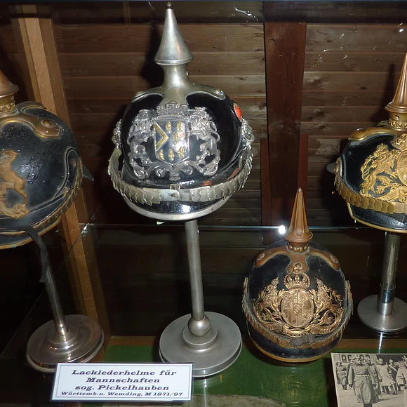 Fünf verschiedene Pickelhauben in einer Vitrine