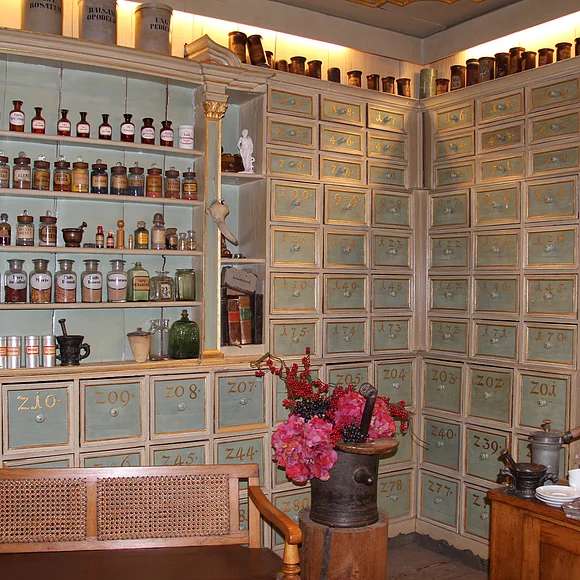 Blick auf einen großen Schrank mit vielen kleinen Schubladen und in Regalen aufgereihten Fläschchen