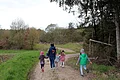 Auf einem Schotterweg laufen eine Frau und mehrere Kinder.