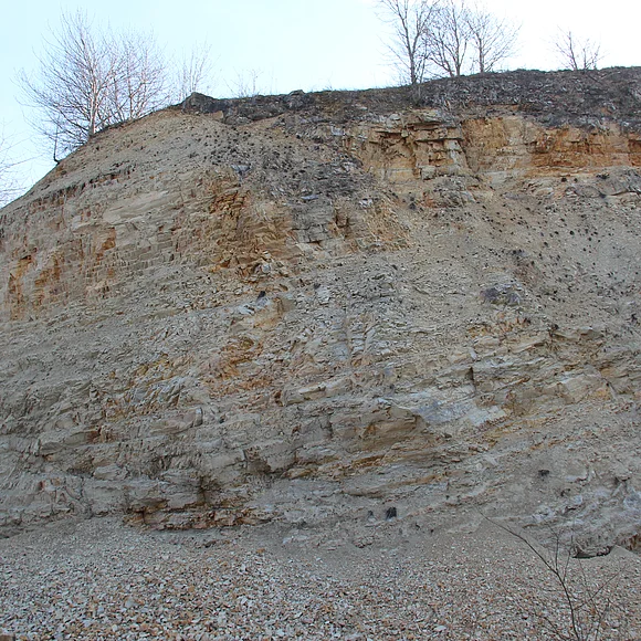 Eine hohe Felswand besteht aus deutlich geschichtetem Gestein.