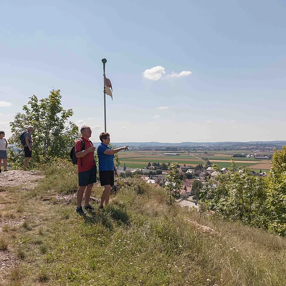 Wanderer auf dem Wallersteiner Felsen, die den Blick ins Ries genießen.