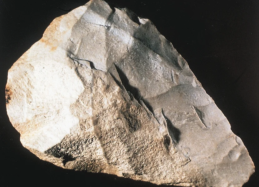 Ein Faustkeil hat eine kegelige Form und einige Kanten auf der Oberfläche.