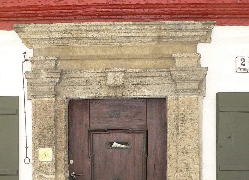 Das Portal mit Gesims einer Holztür ist aus dem Gestein Suevit gefertigt.