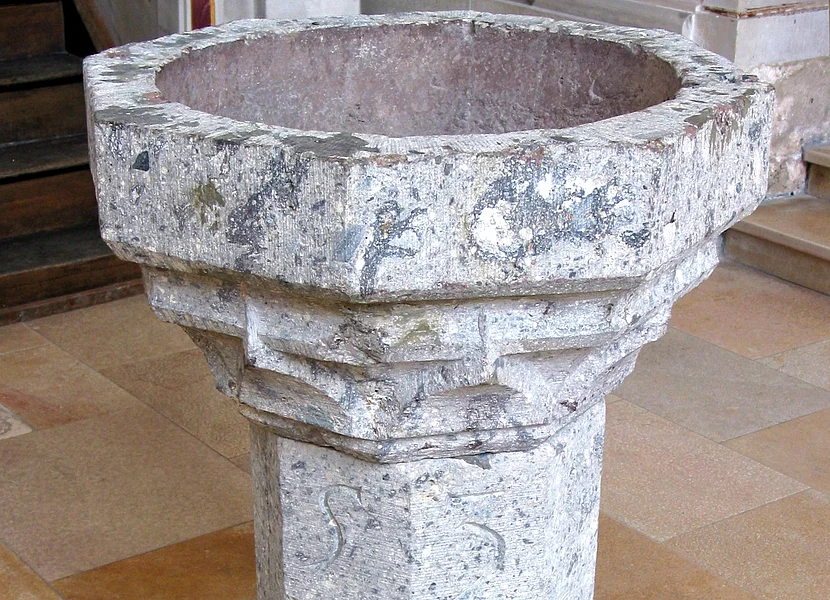 In einer Kirche steht ein aus dem Gestein Suevit gefertigter Taufstein.