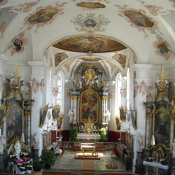 Blick von der Empore auf den hellen Altarraum und die beiden Seitenaltäre.