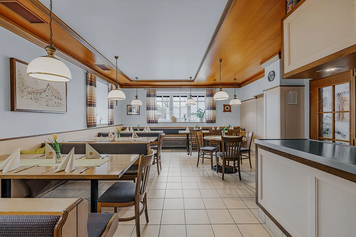 Blick auf die helle Gaststube im Landgasthof Adler mit gedeckten Tischen.