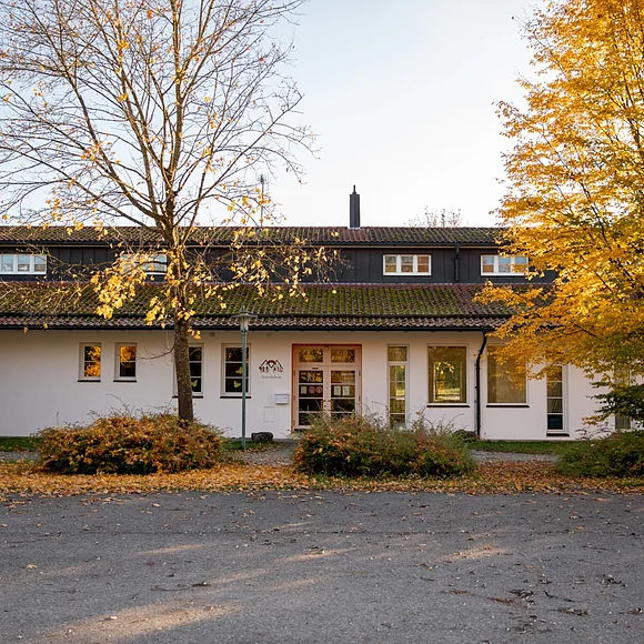 Das Bild zeigt das einstöckige, weiße Schulhaus der Grundschule Maihingen.