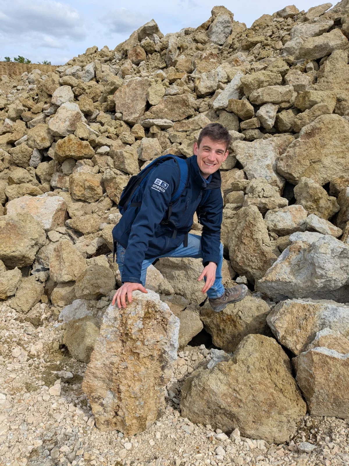 Das Bild zeigt den Geologen des Geoparks Ries vor einer Halde aus gebrochenem Suevit.