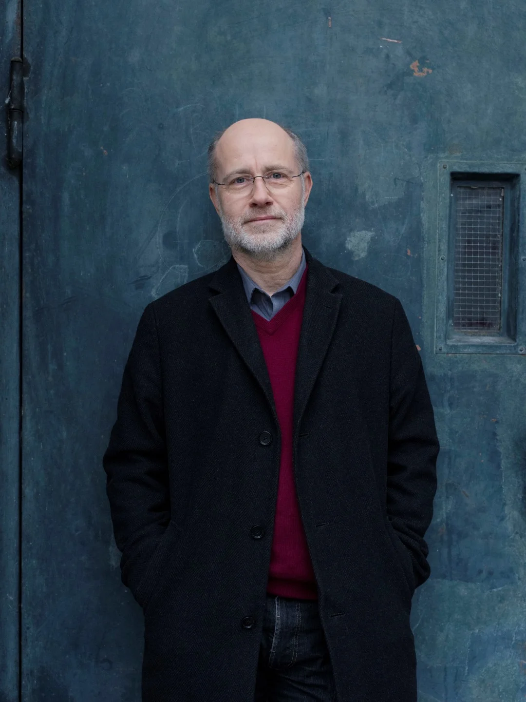 Porträt Prof. Harald Lesch Prof. Harald Lesch steht in einem schwarzen Mantel vor einer dunklen, graublauen Wand und schaut in die Kamera.